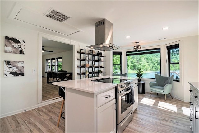 834 Lower Bell Creek Rd, Hiawassee, GA 30546 - kitchen featuring stainless steel electric stove, island exhaust hood, light wood-type flooring, white cabinets, and recessed lighting