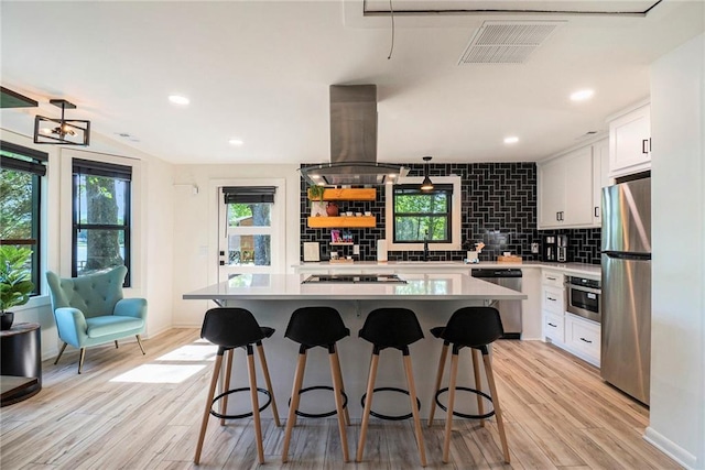 834 Lower Bell Creek Rd, Hiawassee, GA 30546 - kitchen featuring stainless steel appliances, island range hood, backsplash, light wood-style flooring, and white cabinetry