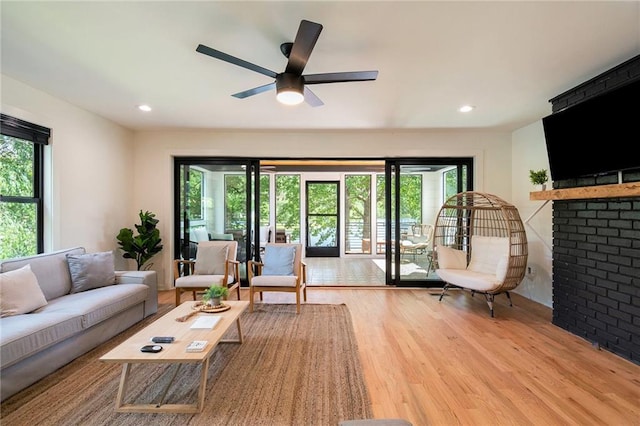 834 Lower Bell Creek Rd, Hiawassee, GA 30546 - living area featuring wood finished floors, a brick fireplace, plenty of natural light, ceiling fan, and recessed lighting