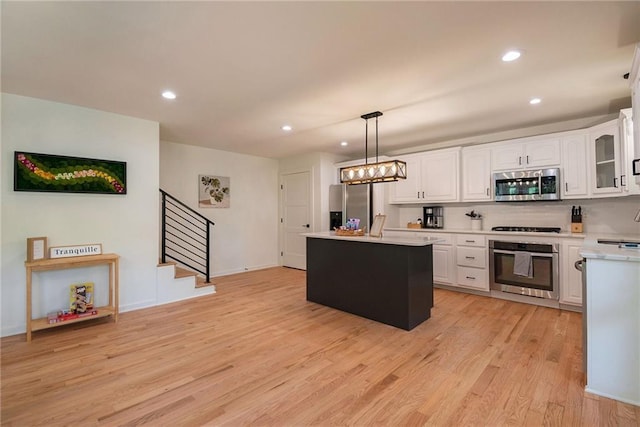 834 Lower Bell Creek Rd, Hiawassee, GA 30546 - kitchen featuring stainless steel appliances, light wood finished floors, light countertops, white cabinets, and a kitchen island