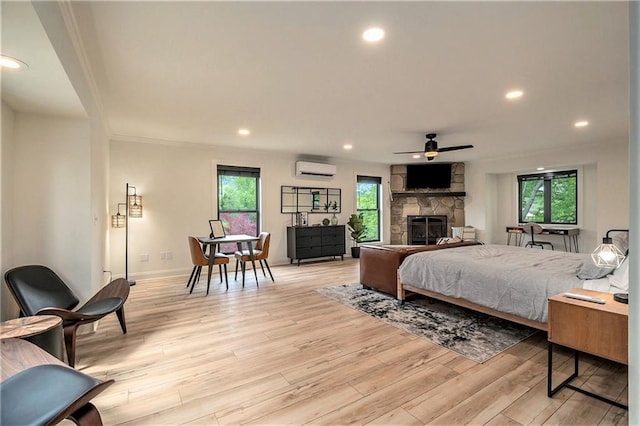 834 Lower Bell Creek Rd, Hiawassee, GA 30546 - bedroom featuring an AC wall unit, light wood finished floors, a stone fireplace, and recessed lighting