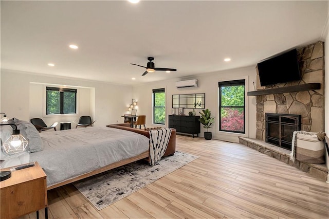 834 Lower Bell Creek Rd, Hiawassee, GA 30546 - bedroom with an AC wall unit, a stone fireplace, wood finished floors, recessed lighting, and ceiling fan