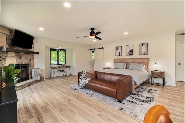 834 Lower Bell Creek Rd, Hiawassee, GA 30546 - bedroom featuring a barn door, a fireplace, light wood-type flooring, recessed lighting, and a ceiling fan