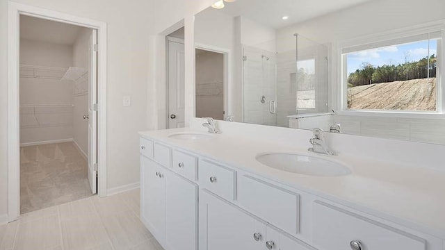 bathroom featuring tile patterned floors, vanity, and a shower with shower door