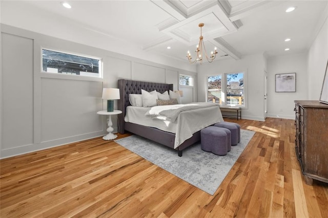 bedroom with coffered ceiling, a notable chandelier, beam ceiling, and light hardwood / wood-style floors