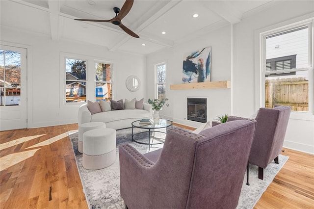 living room with wood-type flooring, coffered ceiling, ceiling fan, and beam ceiling