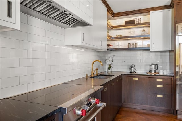 kitchen featuring sink, white cabinetry, dark brown cabinets, dark parquet floors, and wall chimney range hood