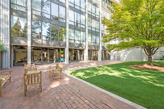 view of property's community featuring a patio and a lawn