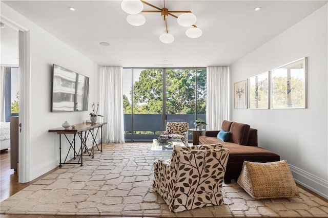 sitting room featuring a healthy amount of sunlight, a wall of windows, and light wood-type flooring