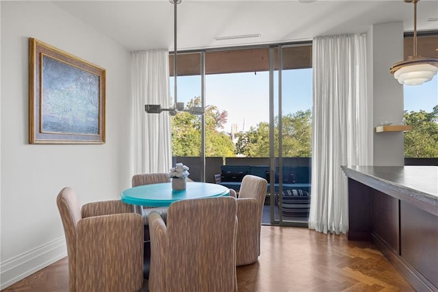 dining area featuring dark parquet flooring and floor to ceiling windows