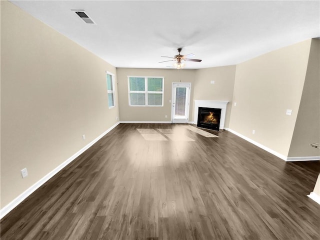 unfurnished living room with ceiling fan and dark hardwood / wood-style flooring