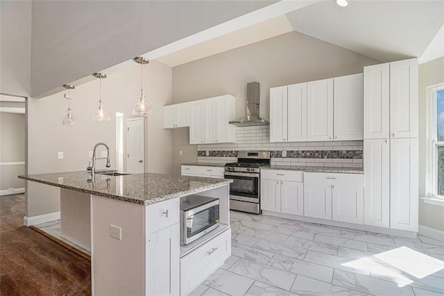 kitchen with wall chimney exhaust hood, appliances with stainless steel finishes, marble finish floor, stone counters, and a sink