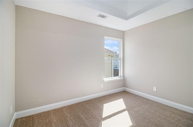 spare room featuring carpet flooring, visible vents, and baseboards