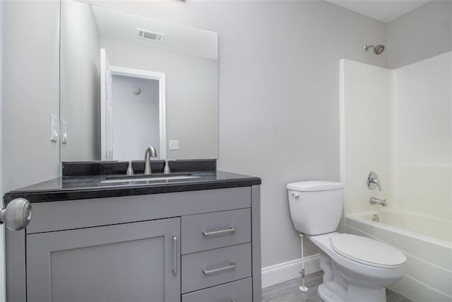 full bath featuring baseboards, visible vents, toilet, vanity, and shower / bathtub combination