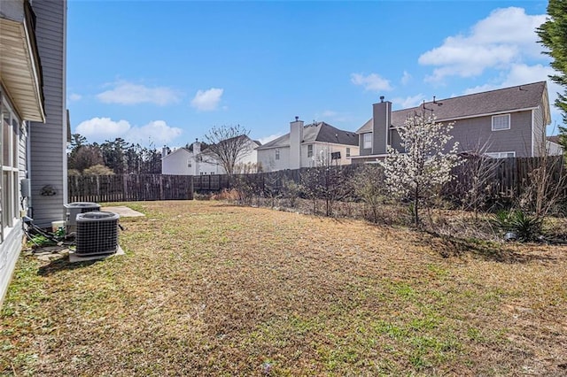 view of yard with a fenced backyard, a residential view, and cooling unit