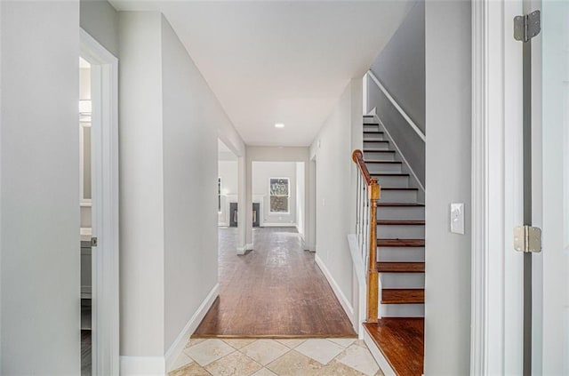 entryway featuring stairs, light tile patterned floors, and baseboards