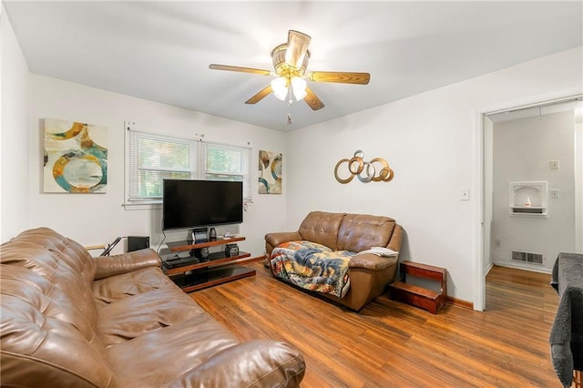 living room featuring wood-type flooring and ceiling fan