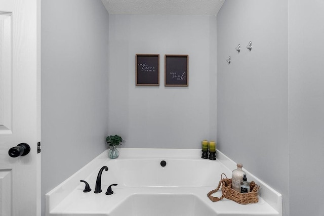 bathroom featuring a tub and a textured ceiling