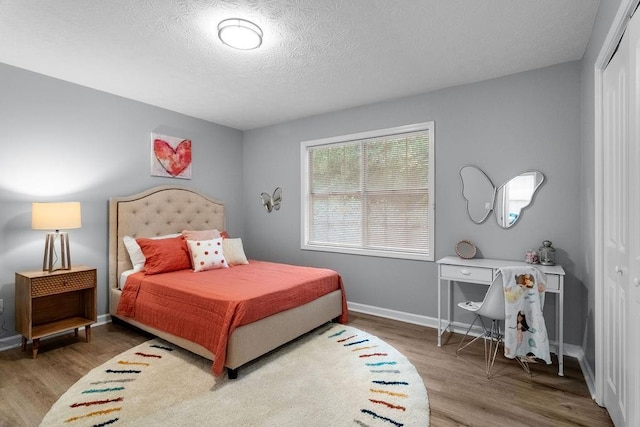 bedroom with hardwood / wood-style flooring, a closet, and a textured ceiling