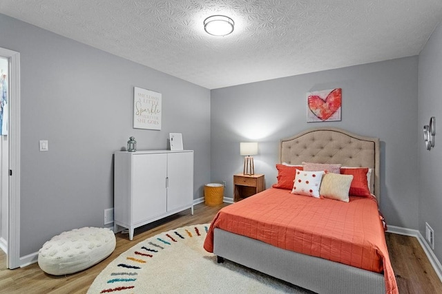 bedroom featuring wood-type flooring and a textured ceiling