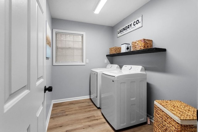 laundry room with washing machine and dryer and light wood-type flooring