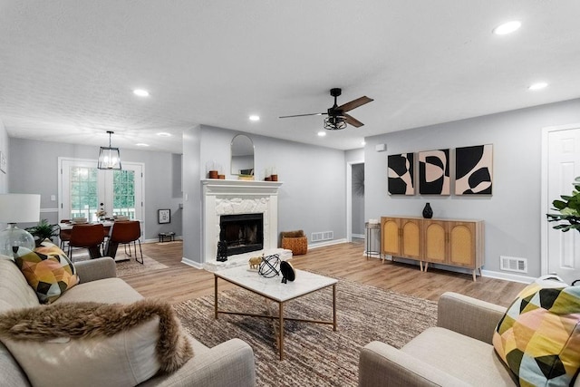 living room with ceiling fan and light hardwood / wood-style flooring