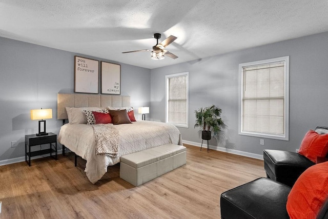 bedroom with ceiling fan, a textured ceiling, and light hardwood / wood-style flooring