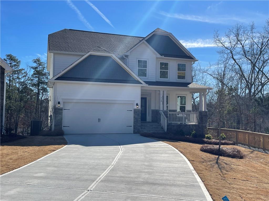 craftsman inspired home with a garage, central air condition unit, and covered porch