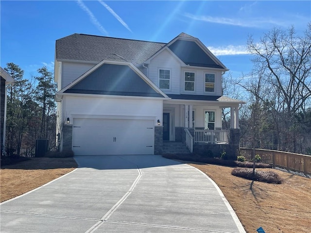 craftsman inspired home with a garage, central air condition unit, and covered porch