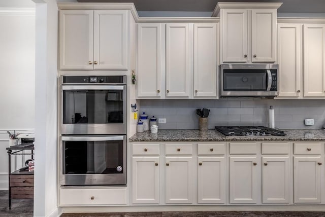 kitchen with stainless steel appliances, stone countertops, and decorative backsplash