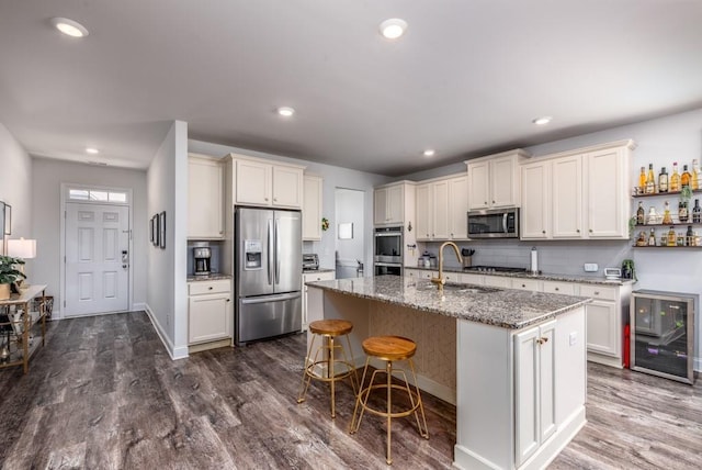 kitchen with stone counters, dark wood-style floors, decorative backsplash, appliances with stainless steel finishes, and a sink