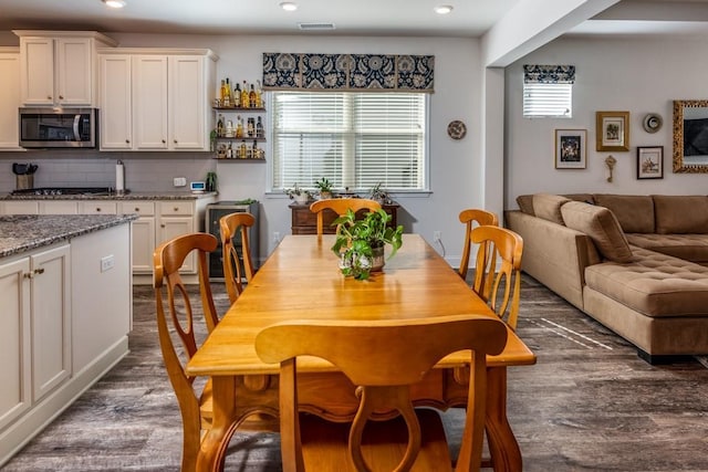 dining room with dark wood finished floors and recessed lighting