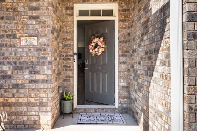 property entrance featuring brick siding