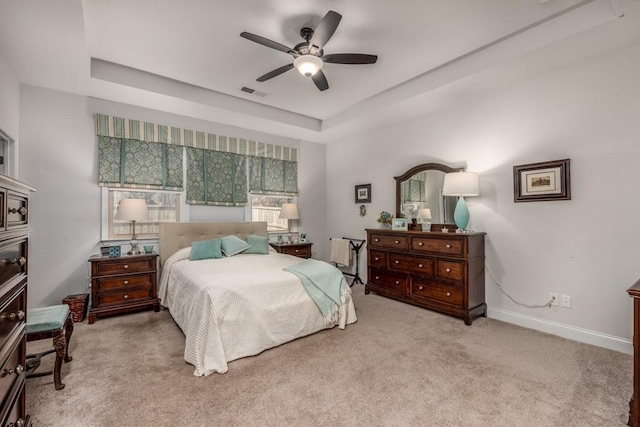 bedroom with ceiling fan, visible vents, baseboards, carpet, and a raised ceiling