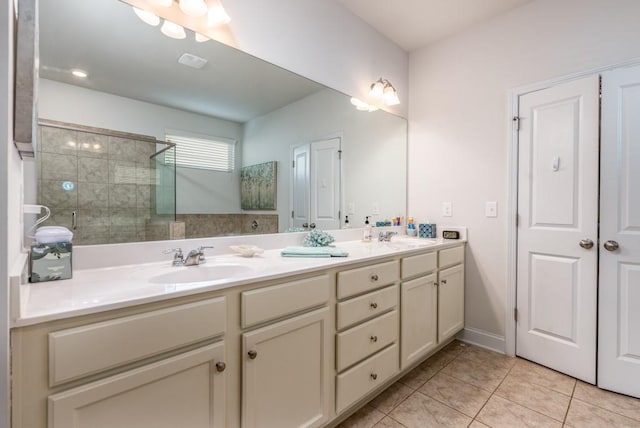 full bathroom with double vanity, visible vents, tile patterned flooring, a walk in shower, and a sink