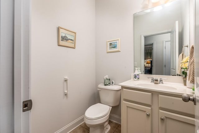 half bathroom with vanity, tile patterned flooring, toilet, and baseboards