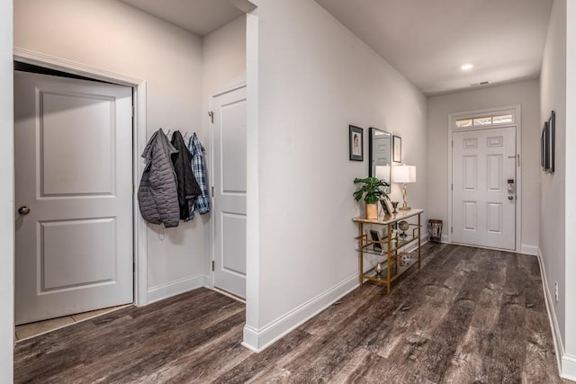 foyer entrance featuring visible vents, baseboards, and wood finished floors