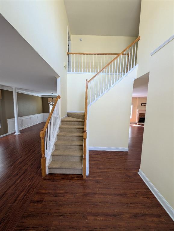3967 Moos Creek Ct, Loganville, GA 30052 - stairway featuring baseboards, a towering ceiling, and wood finished floors
