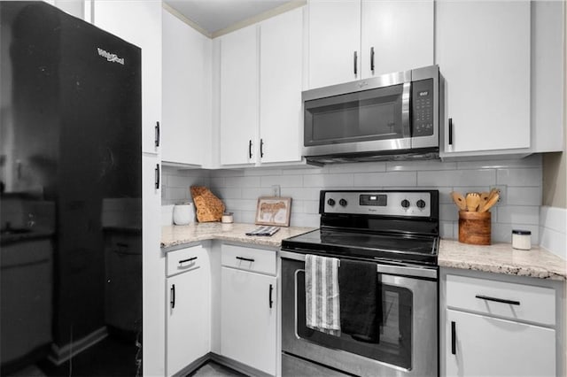 kitchen with stainless steel appliances, tasteful backsplash, and white cabinets