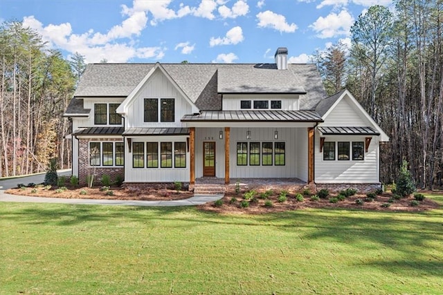 rear view of house with a lawn and a porch