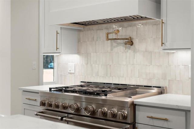 kitchen with high end range, backsplash, and premium range hood