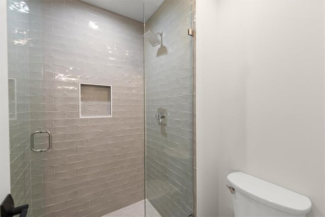 bathroom with toilet and a shower with shower door