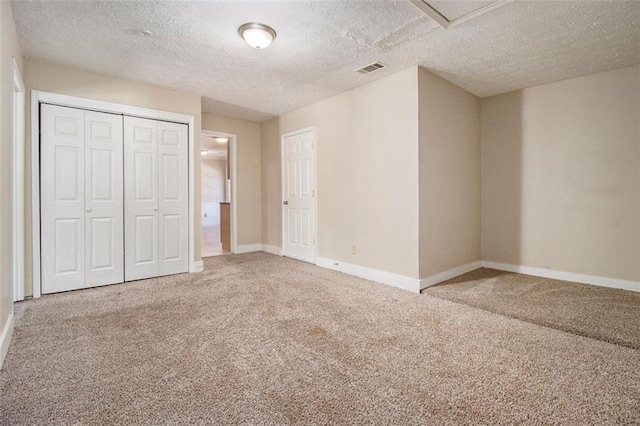 unfurnished bedroom with a closet, carpet floors, and a textured ceiling