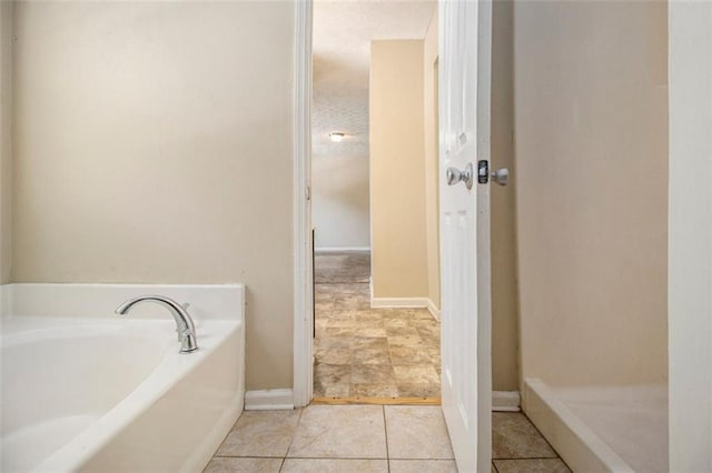 bathroom with a bath and tile patterned flooring