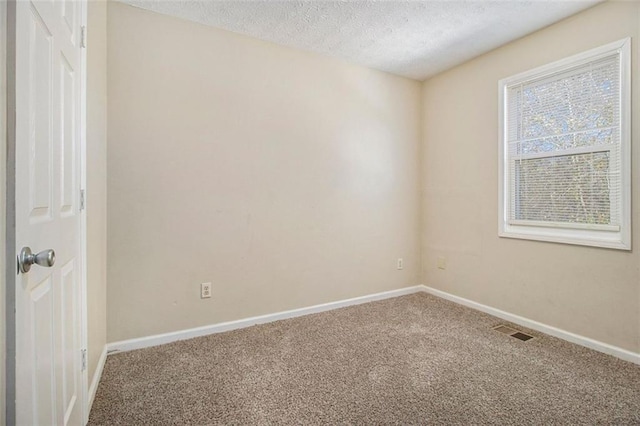 unfurnished room with a textured ceiling and carpet flooring