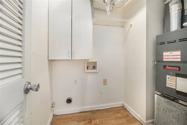 clothes washing area with electric dryer hookup, light wood-type flooring, cabinets, heating unit, and washer hookup