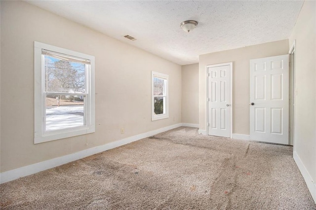 unfurnished bedroom with carpet, a closet, and a textured ceiling