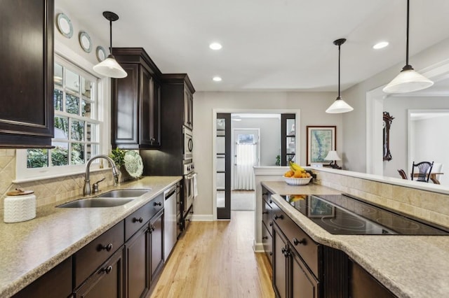 kitchen with black electric stovetop, sink, decorative backsplash, decorative light fixtures, and dark brown cabinetry