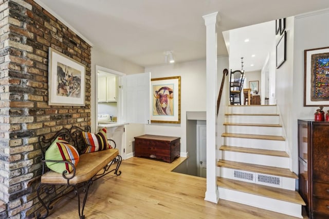 interior space featuring ornate columns and light hardwood / wood-style flooring