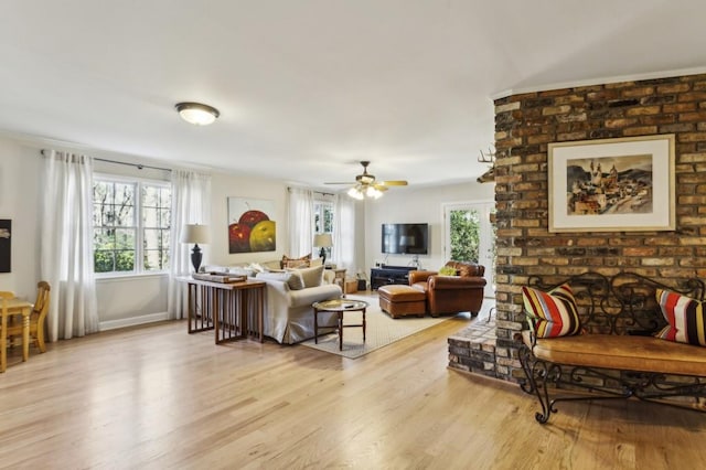 living room with ceiling fan, light hardwood / wood-style flooring, and a brick fireplace